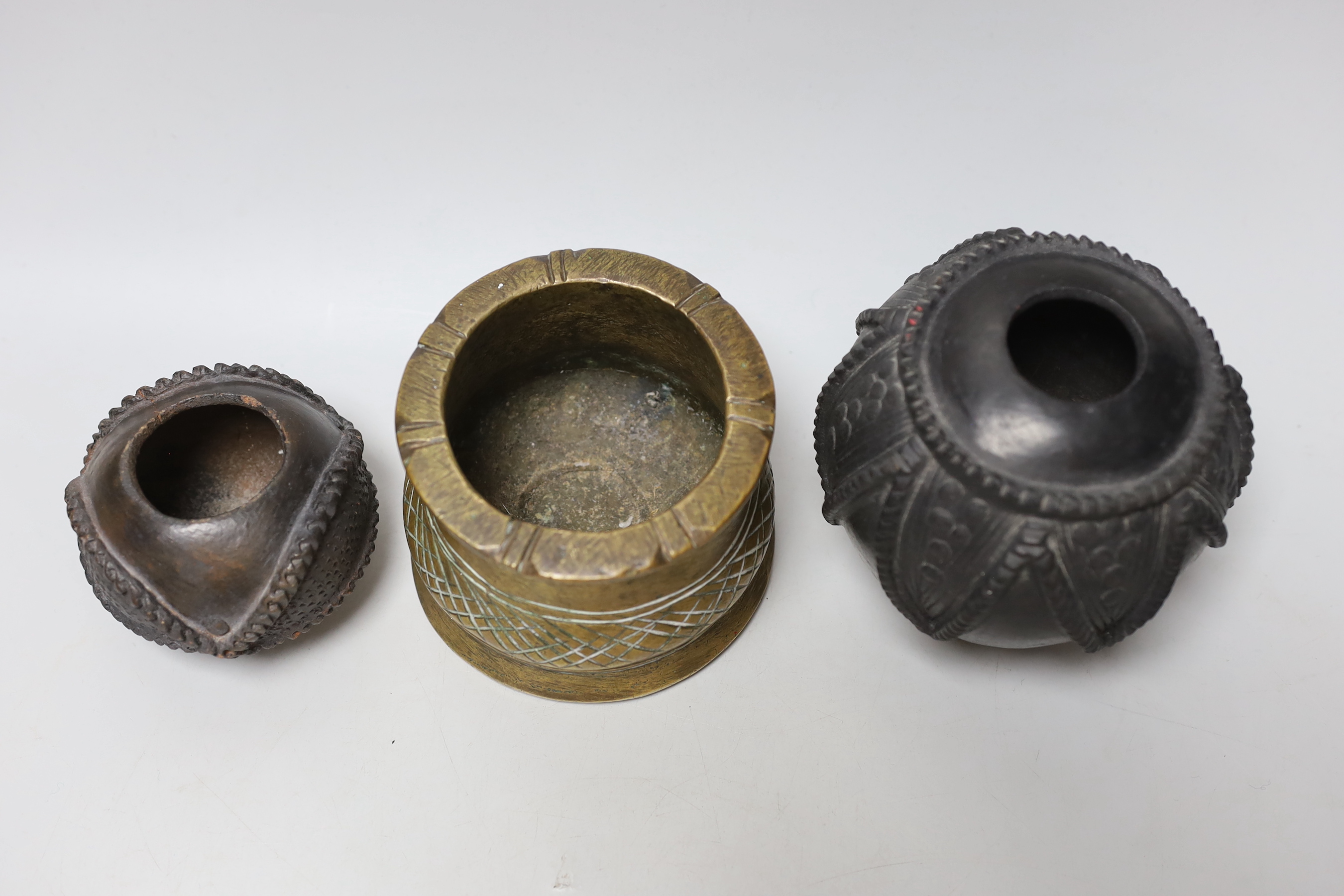 An African bronze mortar and two pots with carved and incised decoration, the largest 12cm high